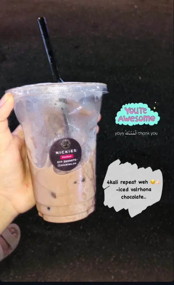 Customer holding a nearly finished Nickies Iced Valrhona Chocolate, with “You're awesome” and “4kali repeat weh” stickers